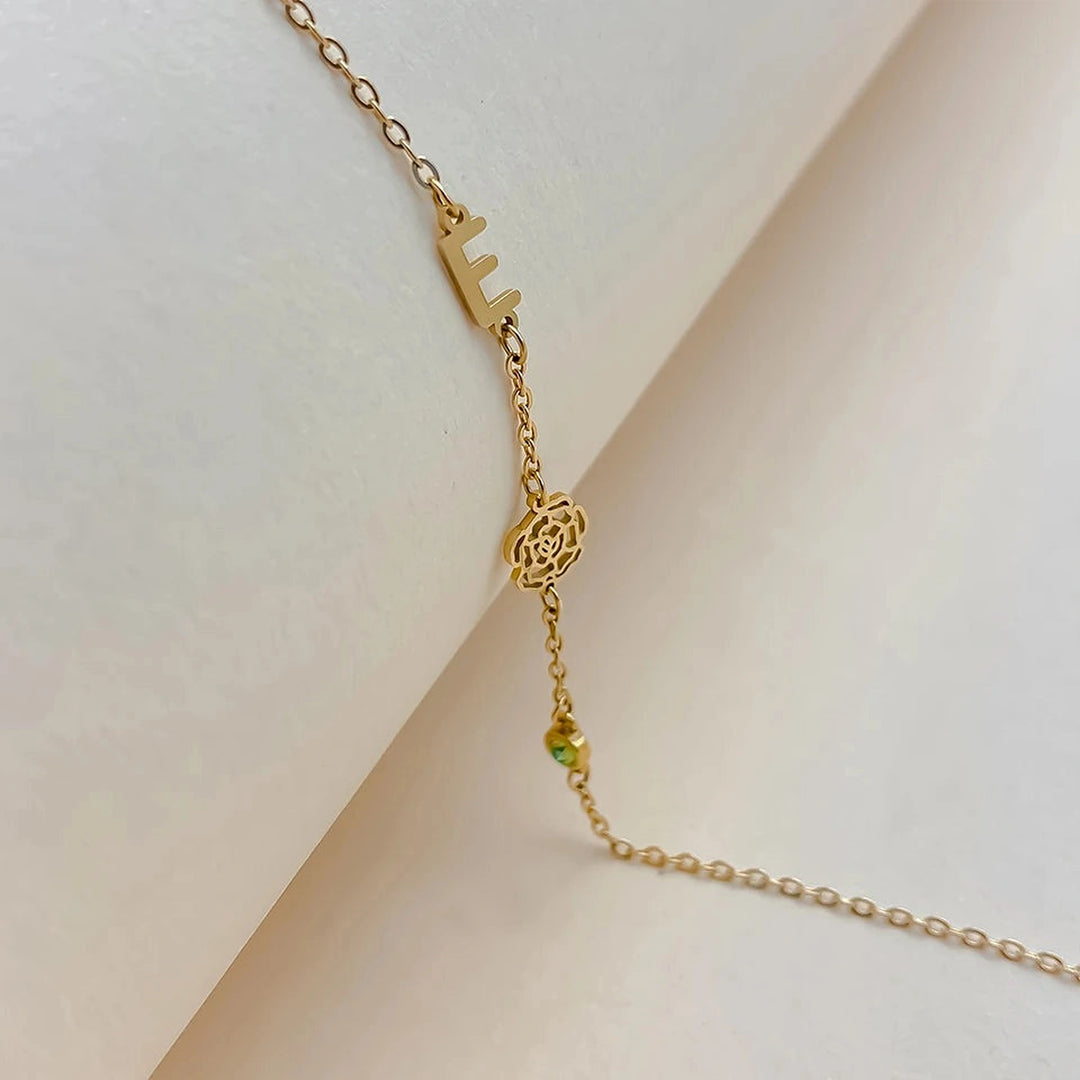 Colar com inicial E, flor vazada e pedra do mês verde dourado