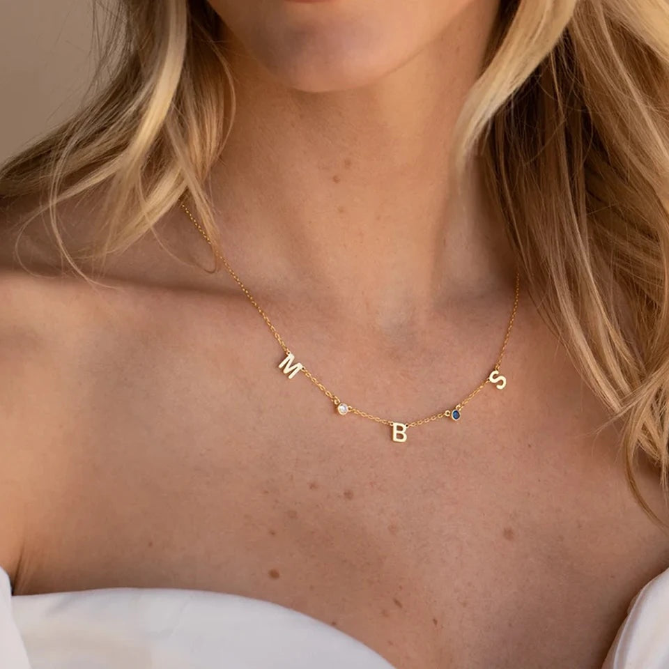 Colar com letras espaçadas dourado usado com vestido branco