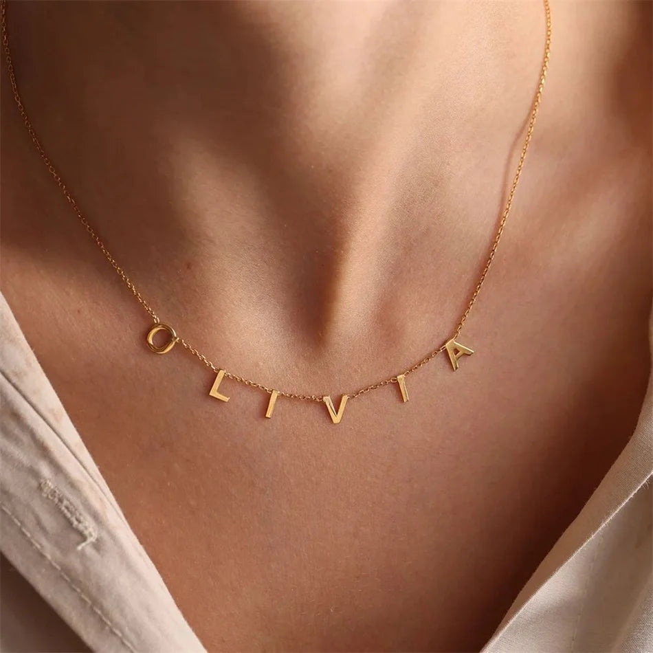 Colar com nome Olivia em letras soltas douradas no colo