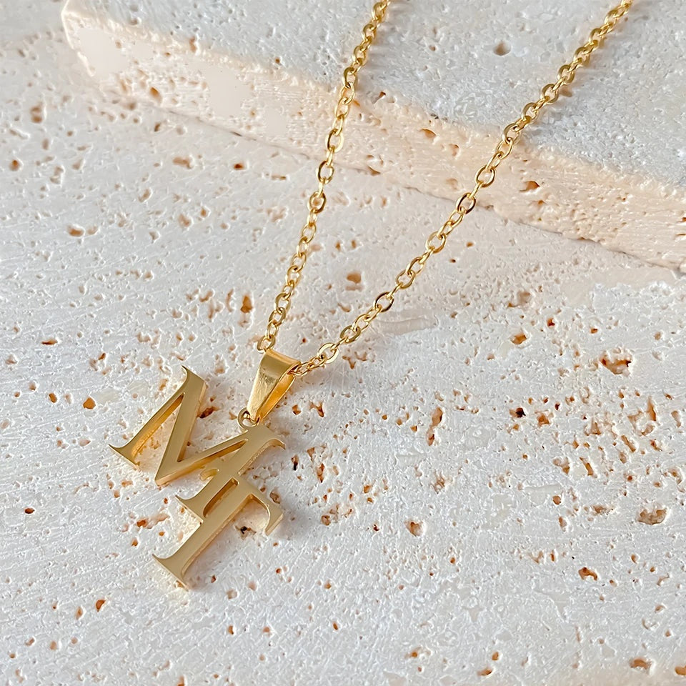 Colar monograma dourado sobre pedra clara