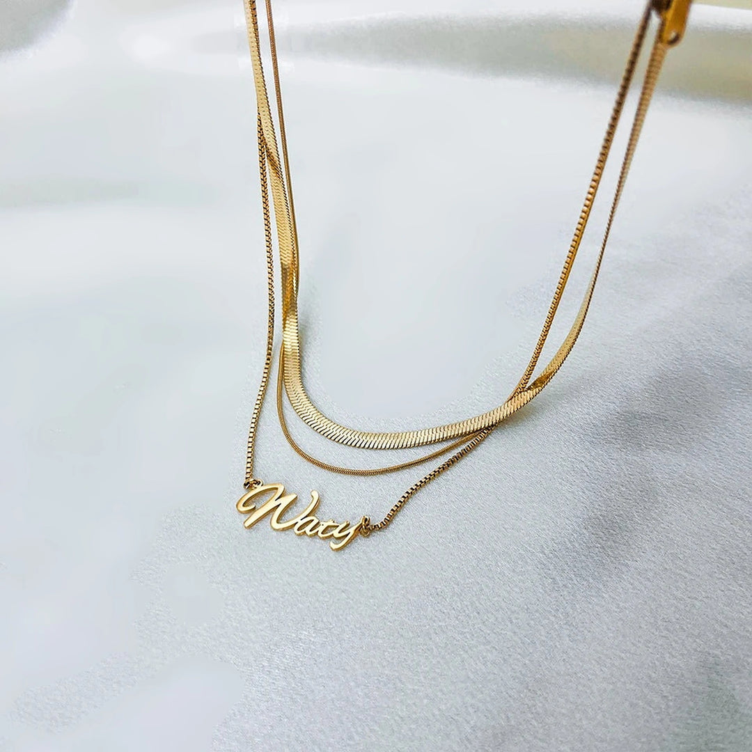 Colar com nome duplo dourado com corrente fita sobre tecido branco