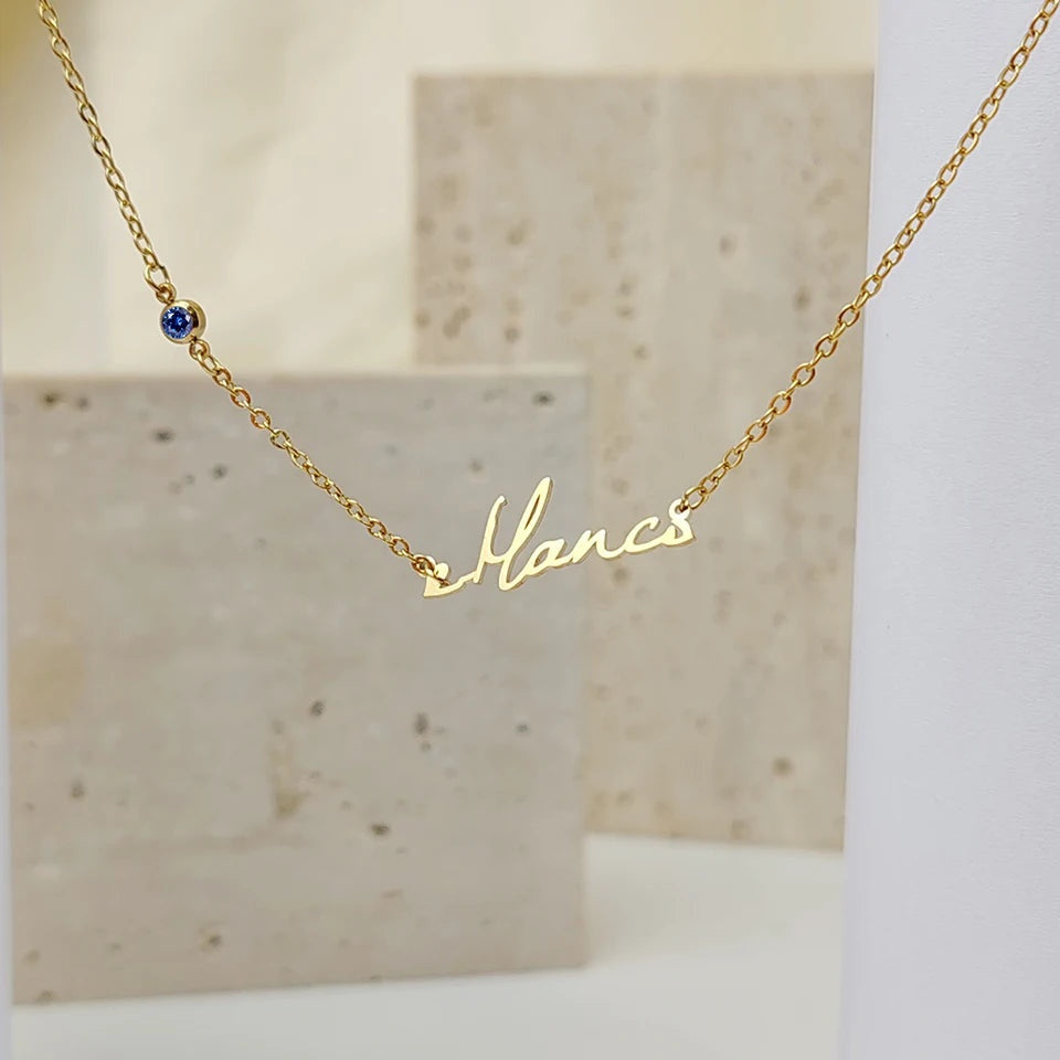 Colar com nome em letra cursiva e pedra azul sobre pedra clara
