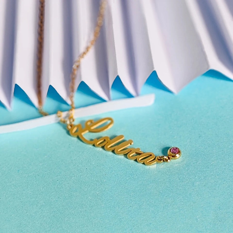 Colar com nome e pedra do mês rosa dourado sobre fundo azul