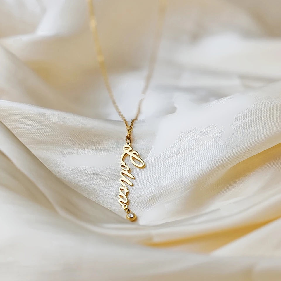 Colar com nome vertical e pedra do mês dourado sobre tecido