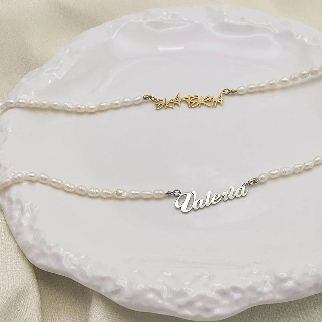 Colares de pérolas de água doce com nome dourado e prata sobre prato branco