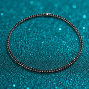 Colar Riviera de Moissanite Negra 3 mm em prata 925 sobre fundo verde com brilho