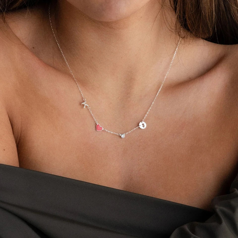 Colar com inicial, coração e signo prata usado com blusa preta