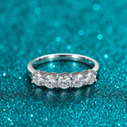 Meia Aliança 5 Pedras de Moissanite 4 mm em prata 925 sobre fundo verde com brilho