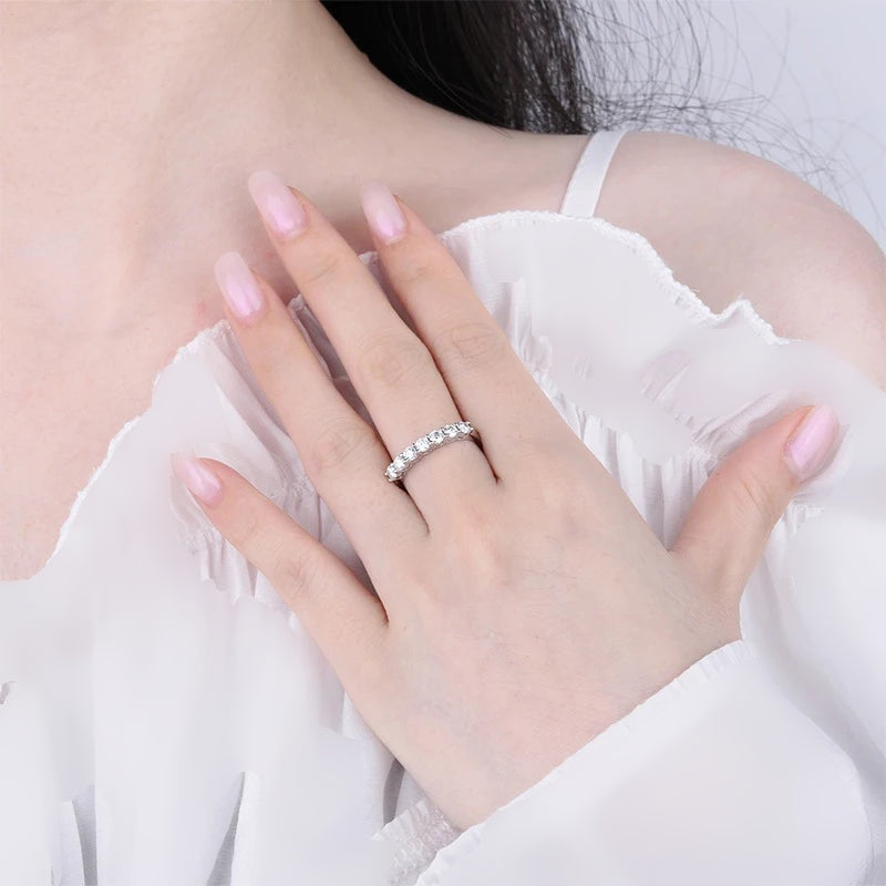 Mão feminina com meia aliança de moissanite