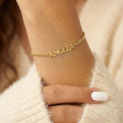 Pulseira com nome Angela em letra de forma dourada no pulso