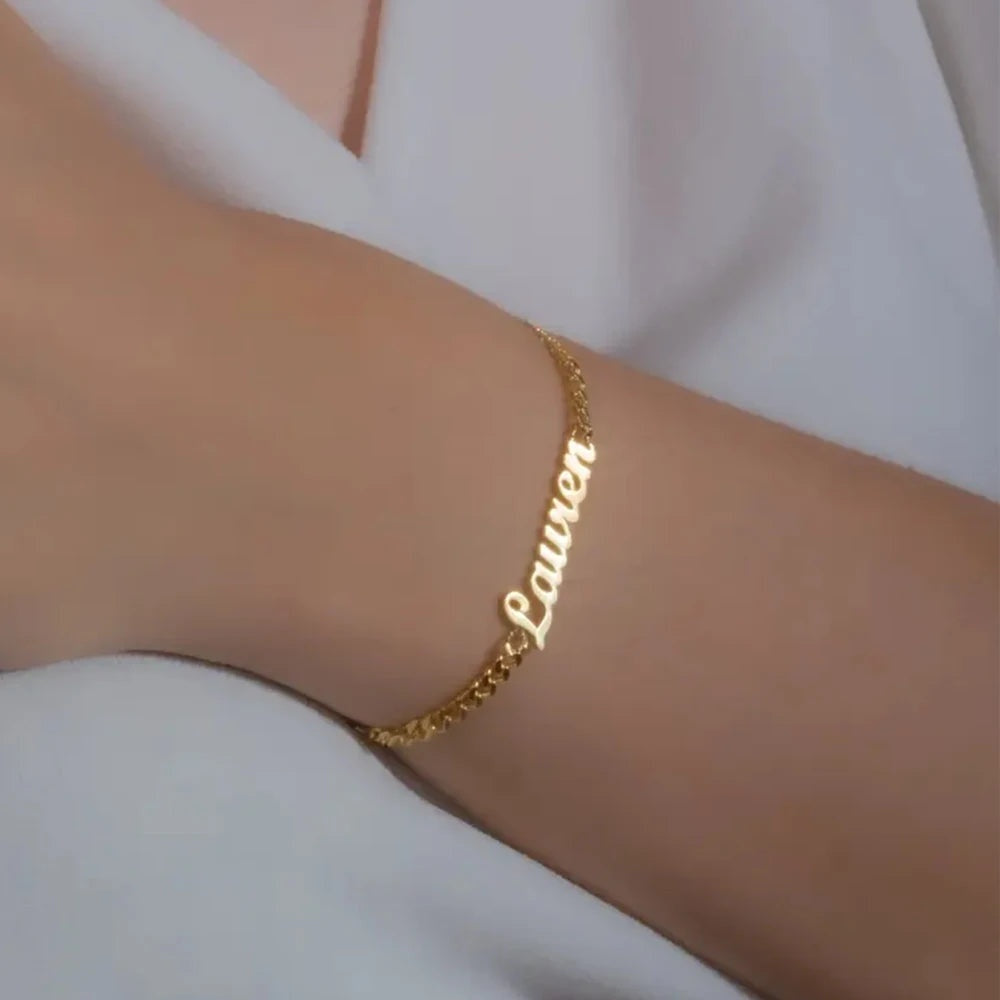 Pulseira com nome Lauren em letra cursiva dourada no pulso