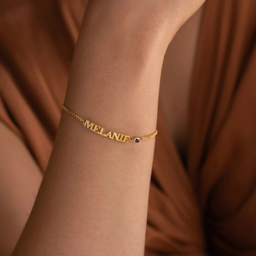 Pulseira com nome Melanie dourada usada no pulso