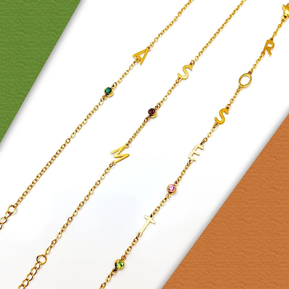 Três pulseiras com iniciais e pedras de nascimento lado a lado