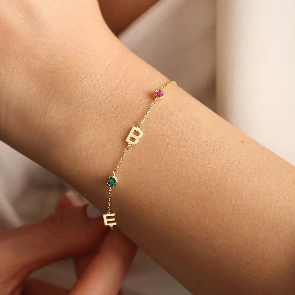 Pulseira com iniciais B e E e pedras do mês usada no pulso