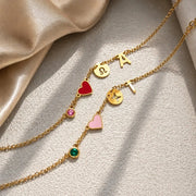 Duas pulseiras personalizadas douradas com coração vermelho e rosa, signo e inicial