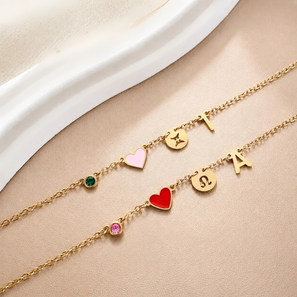 Duas pulseiras com coração, pedra do mês, signo e inicial lado a lado