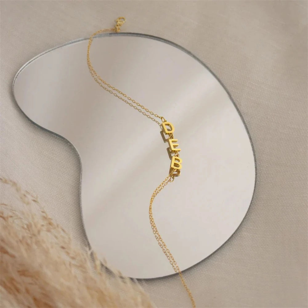 Pulseira com letras laterais douradas sobre espelho