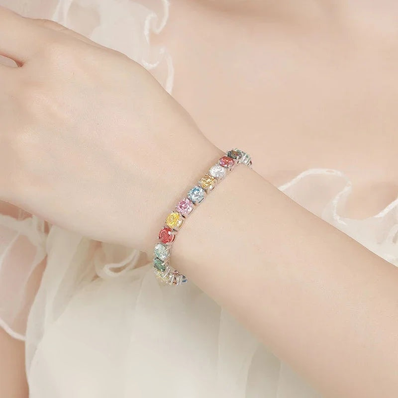 Pulseira riviera arco-íris usada com tecido claro ao fundo