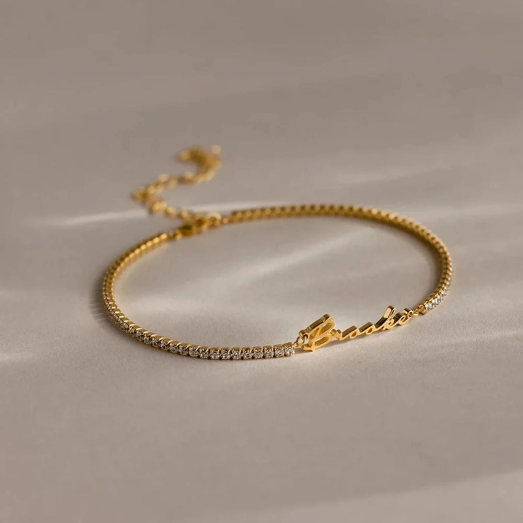 Pulseira riviera com nome em letra cursiva dourada e zircônias