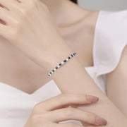 Pulseira riviera preta e branca no pulso