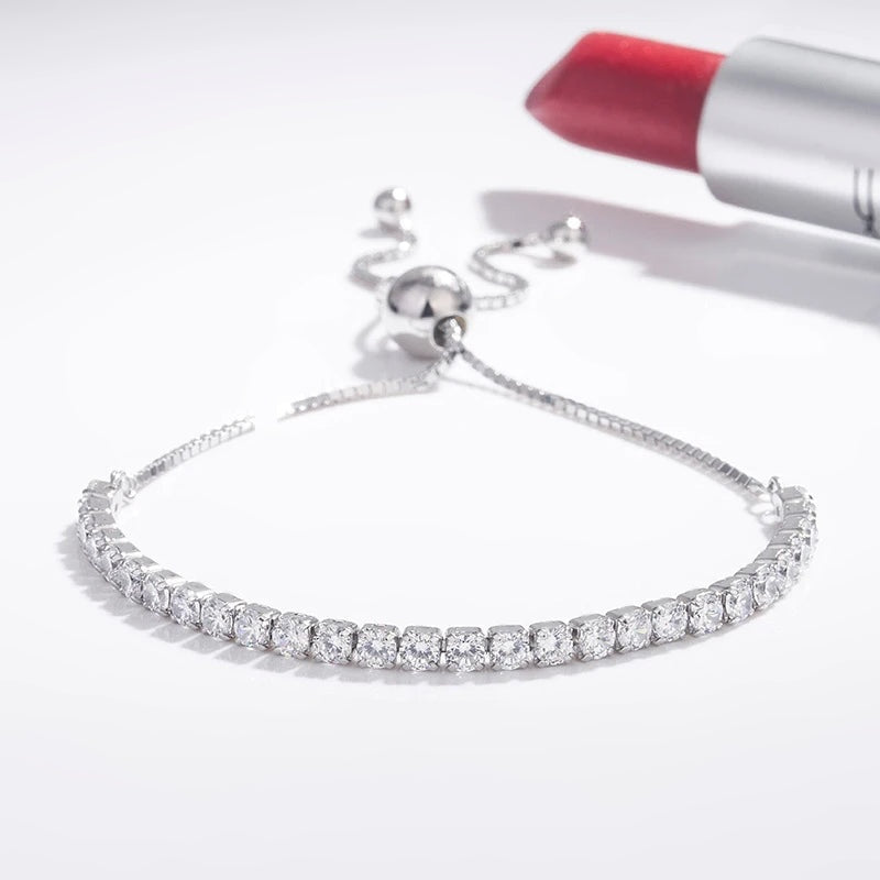Pulseira tennis com fecho de correr apoiada ao lado de um batom